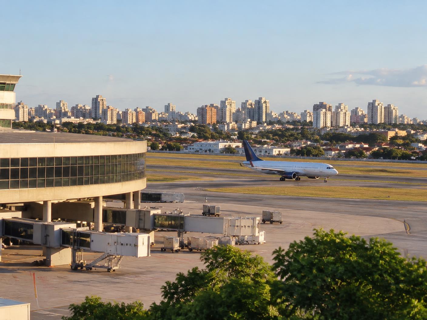 Terminal e pista do Aeroporto de Congonhas, com avião taxiando e a cidade de São Paulo ao fundo